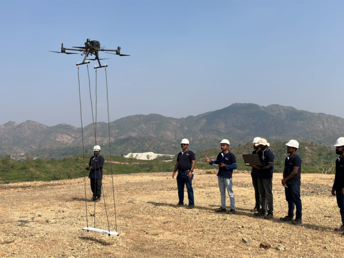 A drone equipped with advanced technology conducts geophysical surveying in a lush green landscape, exploring mineral deposits with precision and minimal ecological impact. The partnership between Squadrone Infra & Mining Pvt. Ltd, PT. Tunas Artha group, and the Chamber of Commerce paves the way for sustainable mineral exploration in Indonesia
